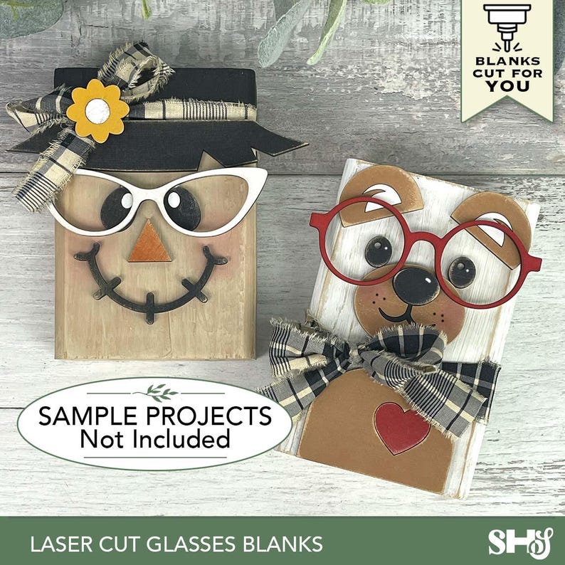 May include: Two wooden block figures, one a scarecrow with white cat-eye glasses and the other a dog with red glasses. Both have decorative bows. The text reads "SAMPLE PROJECTS Not Included" and "LASER CUT GLASSES BLANKS".