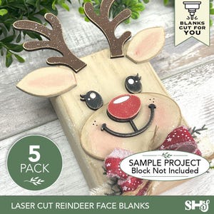 May include: A set of laser-cut wooden reindeer face blanks featuring brown antlers, light tan ears, black eyes, and a red nose. The pieces are designed for assembly, with a red and white patterned fabric bow included as an accent for the reindeer.