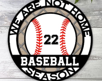 May include: Black and white circle with the text "We Are Not Home Baseball Season" around a baseball with the number 22 on it.