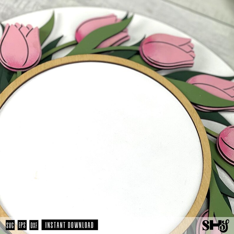 May include: A circular wooden sign featuring a white center panel framed by a light wood border. The outer edge is decorated with layered pink tulip flowers and dark green leaves. The text SVG, EPS, DXF, INSTANT DOWNLOAD, and SHS is visible.