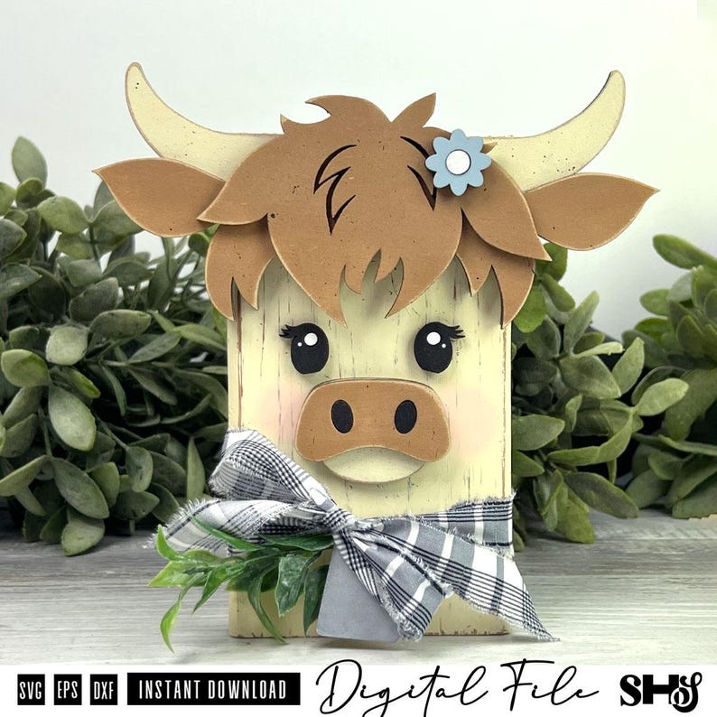 Pu&ograve; includere: Un blocco decorativo in legno a forma di mucca Highland con venature color crema, capelli marroni a strati, corna ricurve e un fiore azzurro. Presenta occhi neri, un muso marrone e un fiocco in tessuto a quadri bianco e nero.