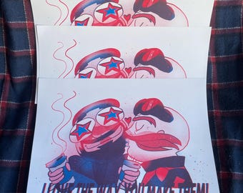 May include: A print of two cartoon characters holding coffee cups. The characters are wearing red, white, and blue clothing and have stars on their eyes. The text "I love the way you make them!" is printed below the characters.