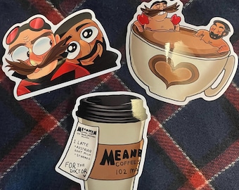 May include: Three stickers featuring cartoon illustrations. The first sticker shows two men with mustaches and large eyes. The second sticker shows two men in a cup of coffee. The third sticker shows a coffee cup with a receipt that says "For the Doctor".