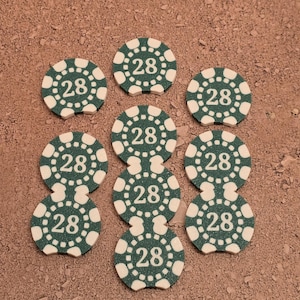 May include: Nine green and white poker chips with the number 28 printed on each chip.