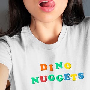 Dino Nuggets T-Shirt: Retro Cartoon Dinosaur Chicken Graphic