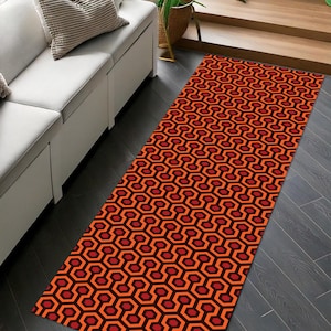 May include: A red and black patterned rug with a geometric design. The rug is made of a soft, durable material and is perfect for adding a touch of style to any room.