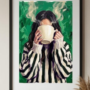 May include: A framed art print depicts a person holding a beige mug, obscured by steam. The person wears a black and white striped sweater against a green textured background. The artwork is in a black frame.