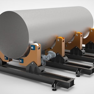 Può includere: Un grande oggetto metallico cilindrico è supportato da una serie di strutture di supporto nere e arancioni. I supporti sono montati su una serie di binari rettangolari neri. L'oggetto sembra essere un'attrezzatura industriale.