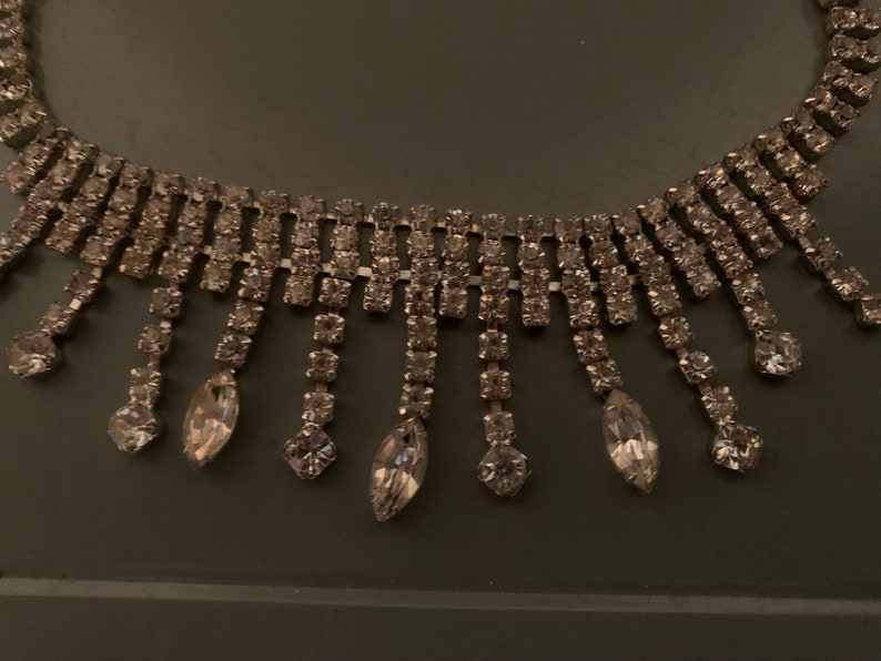 K&ouml;nnte beinhalten: Eine silberne Strass-Choker-Kette mit einer Fransen aus herabh&auml;ngenden Strasssteinen.