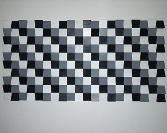 May include: A rectangular wall art piece composed of numerous individual wooden blocks arranged in a grid. The blocks are painted in varying shades of black, white, and gray, creating a textured, three-dimensional geometric pattern.
