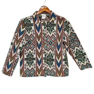 May include: A vintage tapestry jacket with a geometric pattern in shades of green, blue, brown, and pink. The jacket has a button-up front and long sleeves. The tag reads "Redworth".