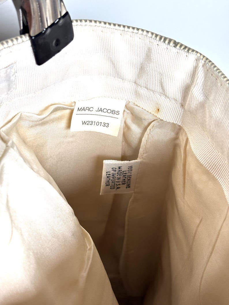Interior lining showing the Marc Jacobs brand tag with style number W2310133 and a material tag.