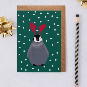 Pinguïn kerstkaart, pinguïn draagt gewei in de sneeuw
