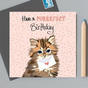 Avoir un anniversaire purrrfect, chaton tenant une enveloppe avec un cœur d’amour