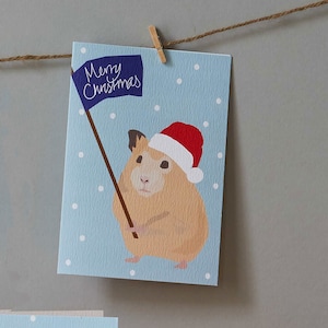 Christmas hamster card, with Santa hat and Christmas flag