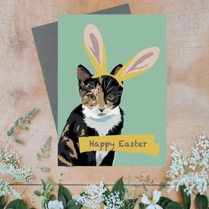 Happy easter greeting card with bunny rabbit ears on tabby cat