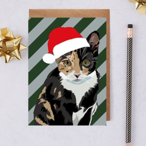 Carte scoute de chat tabby portant un chapeau de Père Noël
