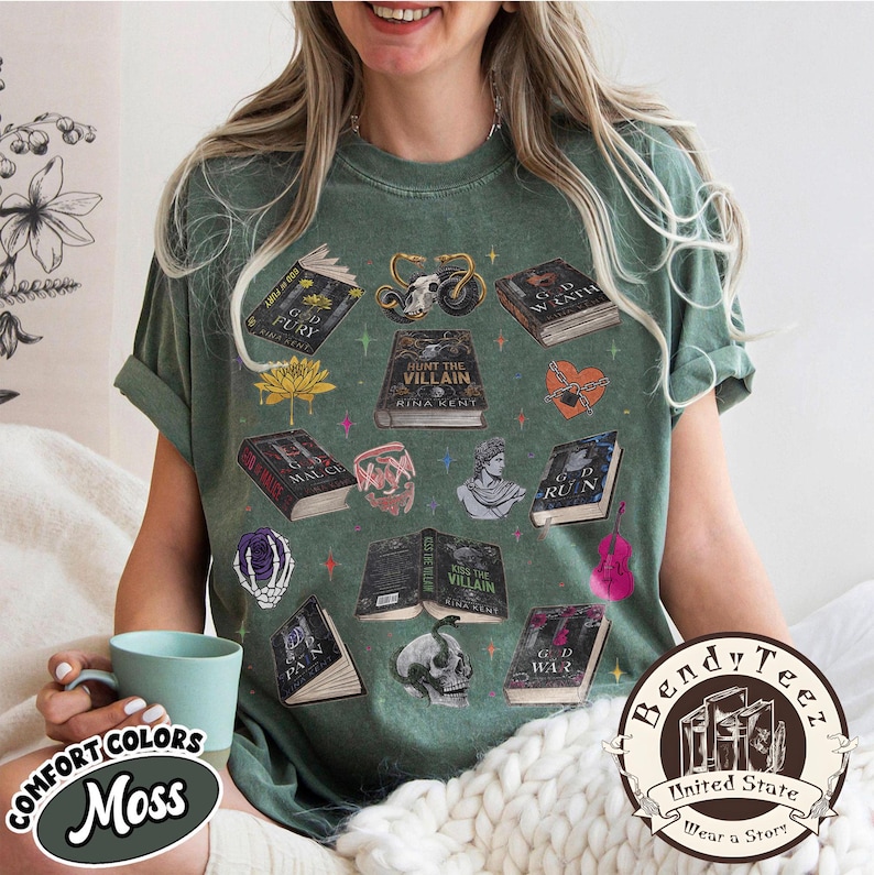 May include: Moss green t-shirt with various book illustrations, a motorcycle, a skull, and other graphics. The shirt features the text "HUNT THE VILLAIN" and "KISS THE VILLAIN". The shirt also has the text "COMFORT COLORS Moss" and "Bendy Tee United State Wear a Story".