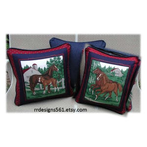 May include: Three square throw pillows featuring horse-themed fabric panels. The pillows have dark blue borders with red polka dots. The central panels depict brown horses in a farm setting with barns and trees. The text rrdesigns561.etsy.com is visible.