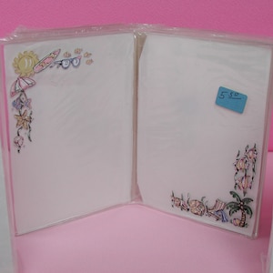 Peut inclure: Un ensemble de deux cartes blanches vierges sur le thème de l'été. Les cartes ont une étiquette de prix bleue qui indique "5,50". Une carte a un soleil, un parapluie, des lunettes de soleil et des coquillages. L'autre carte a un palmier, un parapluie et des coquillages.