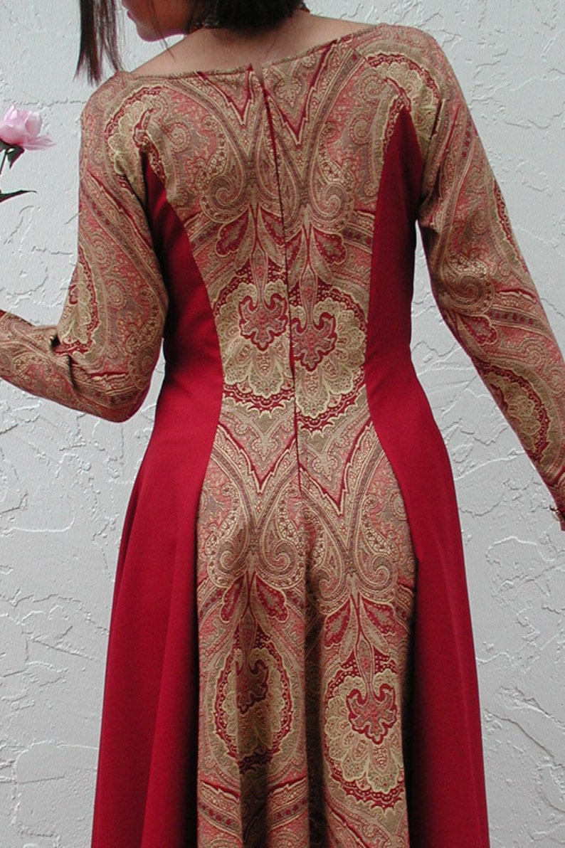 May include: A red dress with a paisley pattern in gold and red. The dress has a fitted bodice and a flowing skirt.