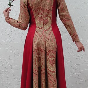 May include: A long red dress with a paisley pattern in gold and brown. The dress has a fitted bodice and a flowing skirt.