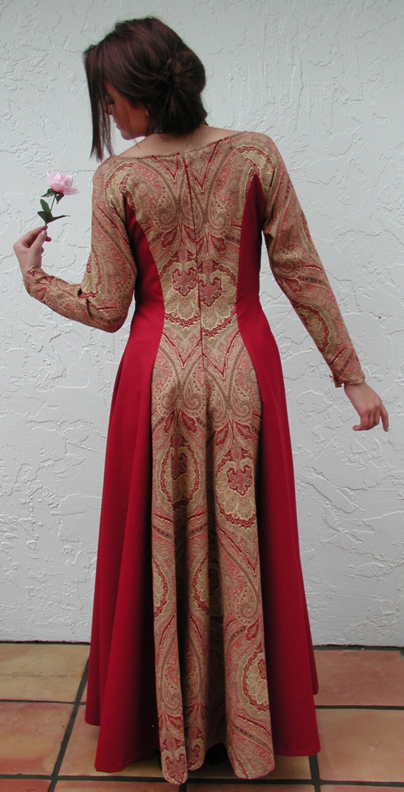 May include: A long red dress with a paisley pattern in gold and brown. The dress has a fitted bodice and a flowing skirt.