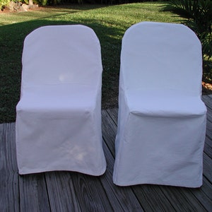 May include: Two white folding chair covers. The covers are made of a smooth, white fabric and are designed to fit over standard folding chairs.