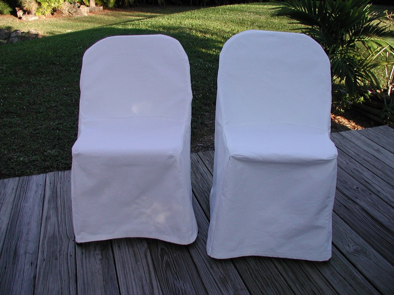 May include: Two white folding chair covers. The covers are made of a smooth, white fabric and are designed to fit over standard folding chairs.