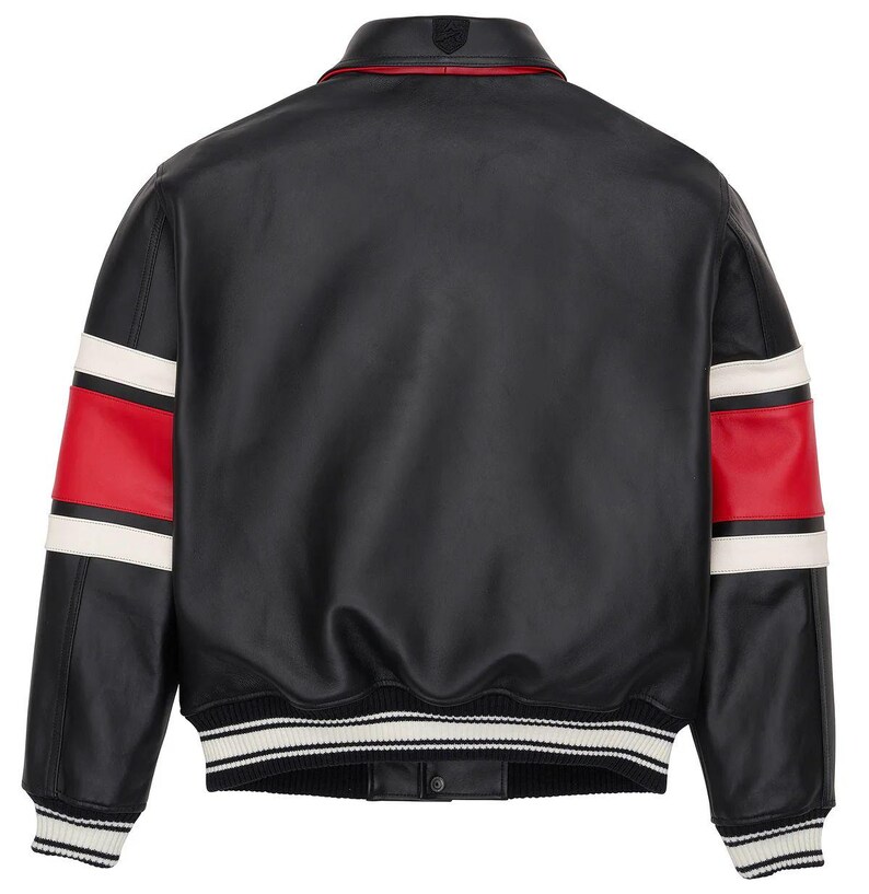 May include: Black leather jacket with red and white stripes on the sleeves. The jacket has a ribbed collar and cuffs with white stripes. A small emblem is visible on the back collar.