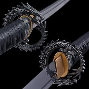 May include: A close-up of a Japanese katana sword. The sword features a black handle wrapped in a textured material. The guard is a detailed dragon design in a dark metallic color. The blade is silver and sharp.
