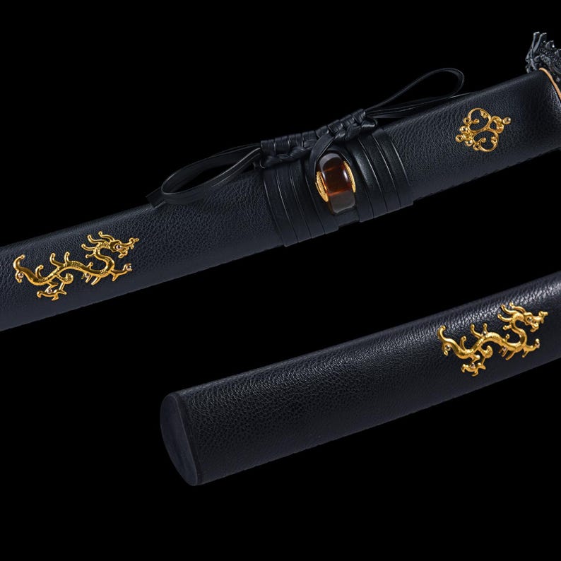 May include: Close-up of a black sword scabbard with gold dragon and decorative accents. The scabbard features a leather texture and a dark brown gem. The sword is a traditional Japanese weapon.