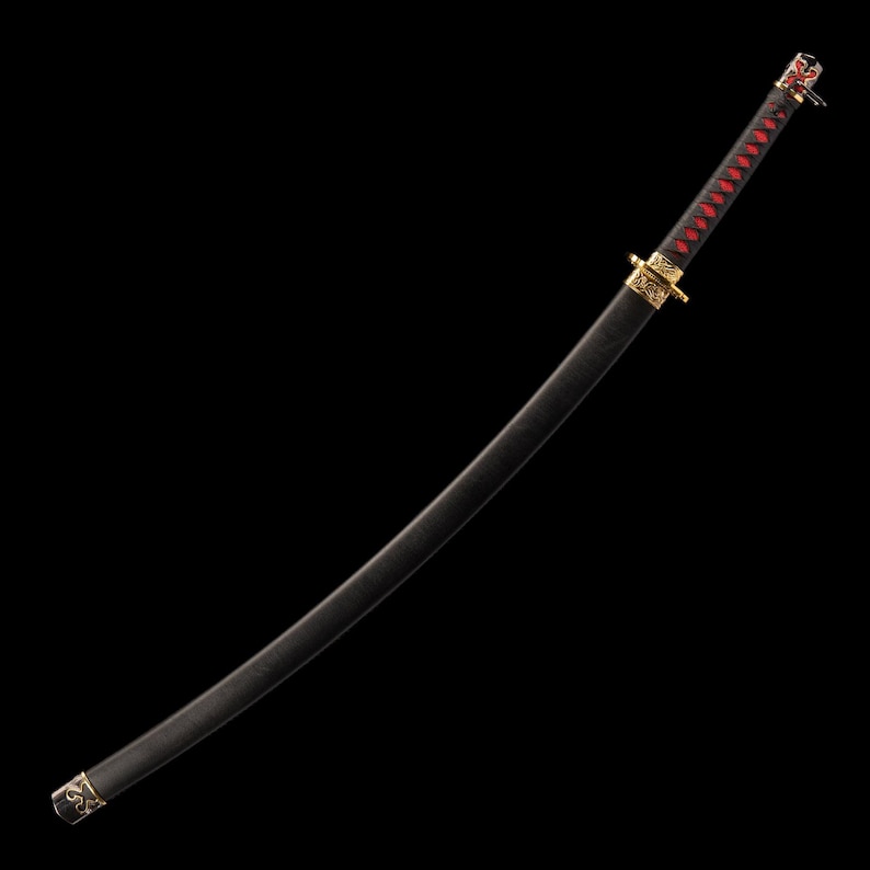 May include: A black katana sword with a curved blade. The handle is wrapped in red and black fabric. Gold-colored accents are visible on the hilt and scabbard. The sword is displayed against a black background.