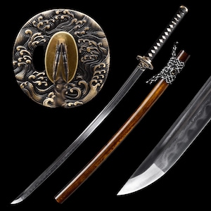 Puede incluir: Una espada katana japonesa con una hoja curva y un mango de madera. La espada presenta una guarda decorativa con un intrincado diseño de olas en oro y negro. La vaina es de color marrón oscuro. El mango está envuelto en un cordón blanco y negro.