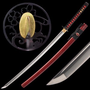 Peut inclure: Un katana japonais avec une lame en acier poli et un fourreau rouge. Le manche est noir avec des losanges rouges. La garde est noire avec un motif floral et un centre dor&eacute;.