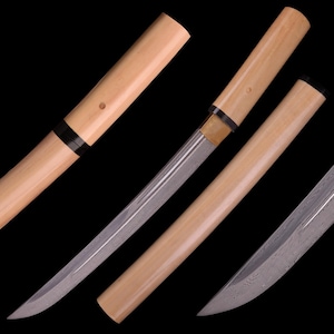 Puede incluir: Una espada japonesa tradicional con una hoja curva y una vaina de madera. La hoja está hecha de acero y tiene un patrón de líneas. La vaina está hecha de madera y tiene un ribete negro y dorado.