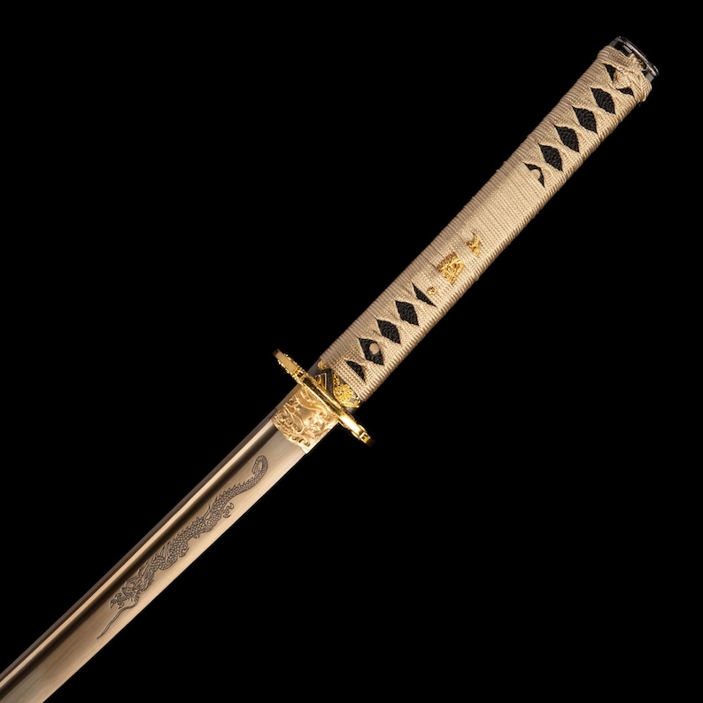 May include: A Japanese katana sword. The hilt and guard are gold, and the handle is cream-coloured with a diamond pattern. The blade features a dragon engraving. The sword is set against a black background.