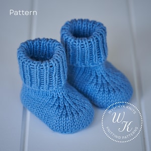 Peut inclure: Une paire de chaussons de bébé tricotés en bleu vif. Les chaussons ont une manchette côtelée et un motif de point texturé. Le mot "Pattern" est visible. Le logo "Wyminya Knits" est en bas à droite.