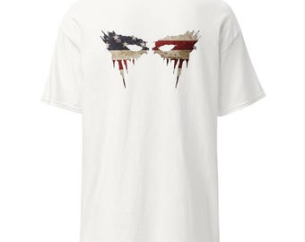 Peut inclure: T-shirt blanc avec un motif vieilli de deux motifs en forme d'yeux, chacun intégrant les étoiles et les rayures du drapeau américain. Le design a une esthétique grunge avec des accents dégoulinants.