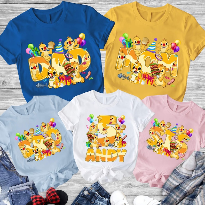 以下が含まれることがあります： 誕生日をテーマにしたデザインのカラフルなTシャツ5枚。各シャツには、「DAD」、「MOM」、「5」、「STS」などの大きな単語や数字が、漫画のキャラクター、風船、ギフトとともに表示されています。シャツの色は青、黄色、水色、白、ピンクです。