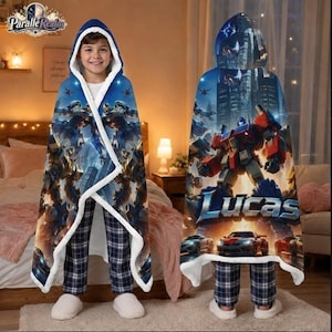 May include: A hooded blanket featuring a blue and orange robot character graphic with the text Lucas, set against a city background. The blanket has a white sherpa lining and is shown draped over a person wearing blue and white plaid pajama pants.