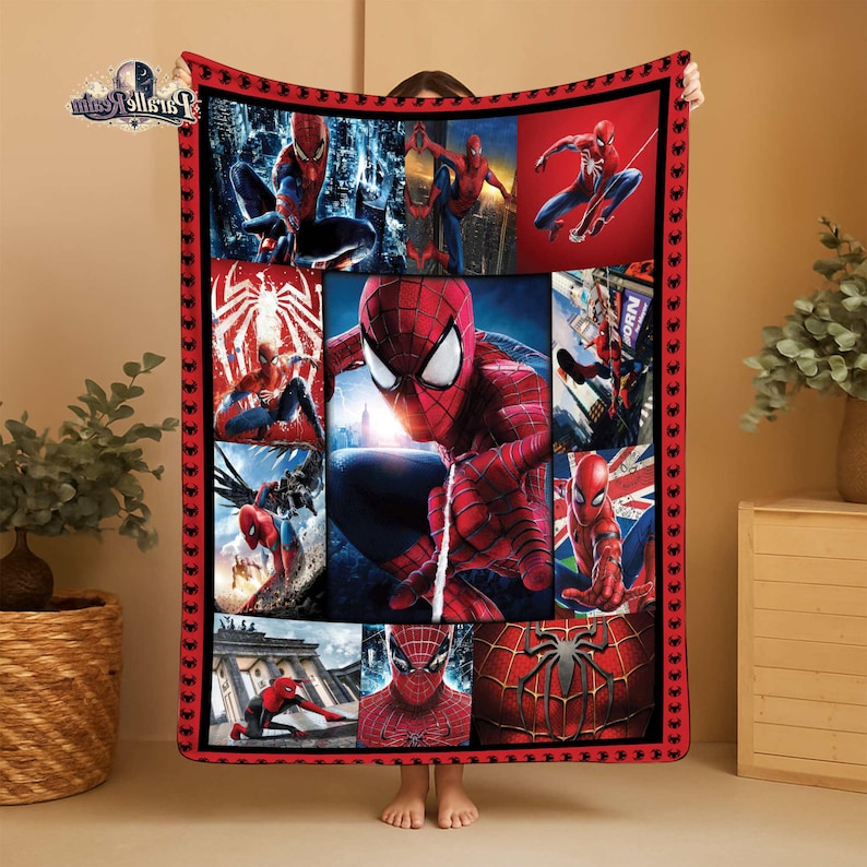 Puede incluir: Una manta roja y negra con tem&aacute;tica de Spider-Man. La manta presenta m&uacute;ltiples im&aacute;genes de Spider-Man en varias poses de acci&oacute;n. El borde es rojo con iconos de ara&ntilde;as negras. La manta est&aacute; sujeta por una persona.