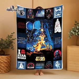 May include: A Star Wars-themed blanket featuring iconic characters and quotes. The design includes Darth Vader, Luke Skywalker, and other characters from the film series. The blanket has a blue and black color scheme with various Star Wars logos and text.