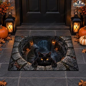 May include: A rectangular doormat featuring a 3D optical illusion of a stone well. A black cat with glowing orange eyes peers out from the center. The design includes stone textures, small glowing jack-o'-lanterns, and a dark metal gate background.
