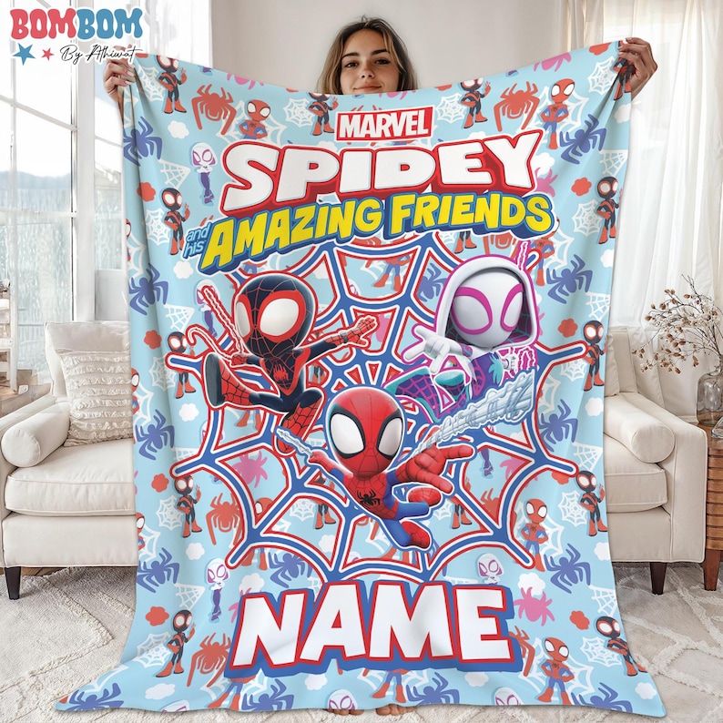 A person is holding up a blanket featuring the characters Spider-Man, Spider-Man and Spider-Man-like figures, along with the text "MARVEL SPIDEY AMAZING FRIENDS" and "NAME".