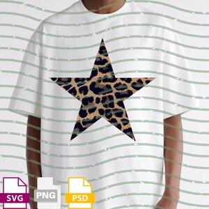 Op de afbeelding: Wit T-shirt met een grote ster met luipaardprint. De ster staat centraal op het shirt. Het shirt heeft korte mouwen en een ronde hals. De achtergrond heeft lichtgroene horizontale strepen.