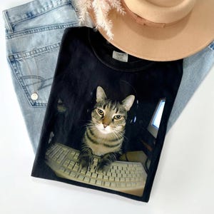 May include: A set of three ceramic mugs with a speckled, matte finish. The mugs are in shades of cream, light gray, and dark gray. Each mug has a simple, minimalist design, perfect for coffee or tea.