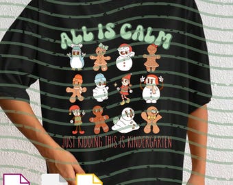 May include: Black t-shirt with the text "ALL IS CALM" in green above a grid of cartoon gingerbread people and snowmen. Below the grid, the text reads "JUST KIDDING THIS IS KINDERGARTEN".