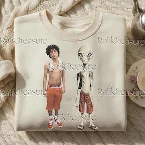 May include: Cream-colored sweatshirt featuring a graphic of two figures: a person in orange shorts and red sneakers, and an alien in red shorts and sandals. The text "Rafik Treasure" is printed on the sweatshirt.