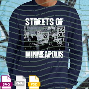 May include: Navy blue long-sleeve sweatshirt with the text "STREETS OF MINNEAPOLIS" in white. The design includes a black and white image of a protest with signs that read "ICE OUT".